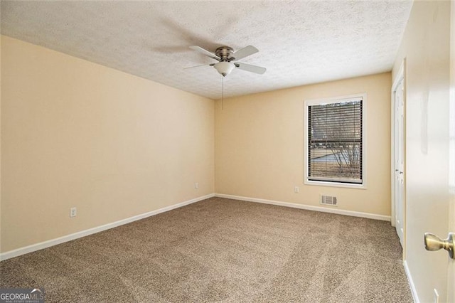 carpeted spare room featuring ceiling fan and a textured ceiling