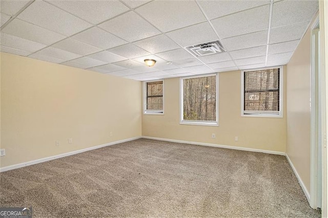 unfurnished room featuring a healthy amount of sunlight, carpet flooring, and a paneled ceiling