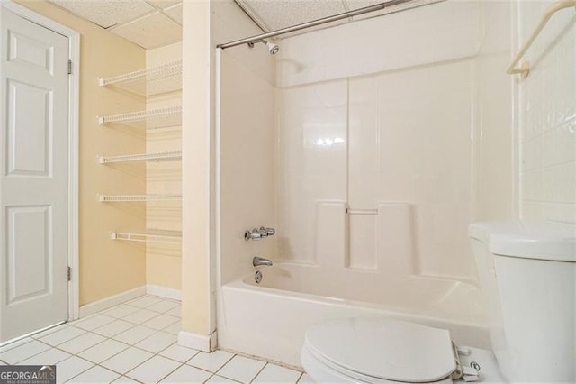 bathroom featuring tile patterned flooring, a paneled ceiling, shower / bathtub combination, and toilet