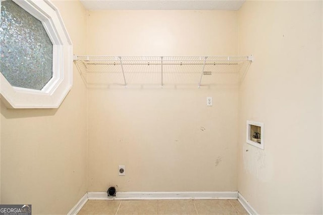 clothes washing area with electric dryer hookup, washer hookup, and light tile patterned floors