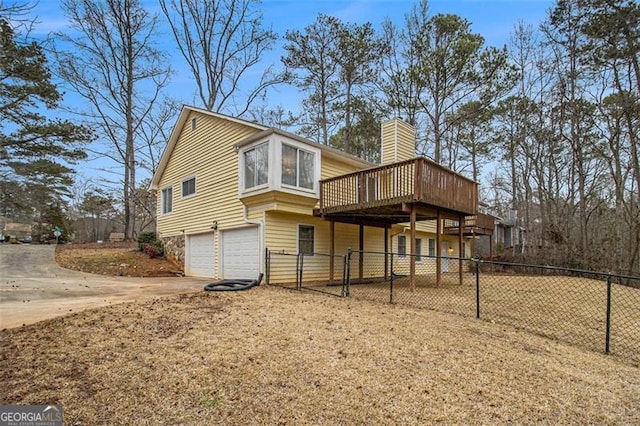 back of house featuring a garage and a deck