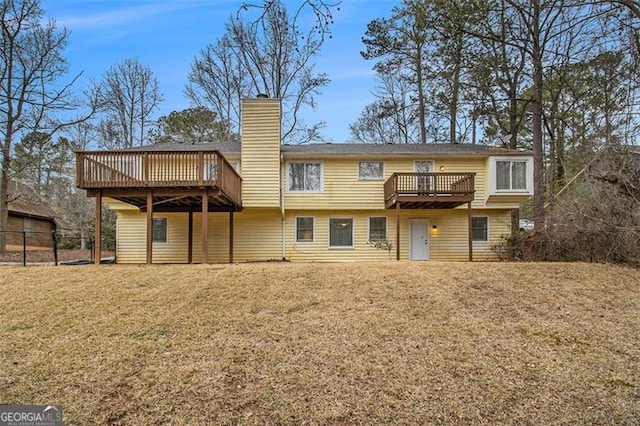 rear view of property with a deck and a lawn