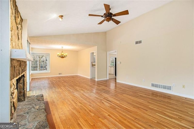 unfurnished living room featuring lofted ceiling, ceiling fan with notable chandelier, and wood-type flooring