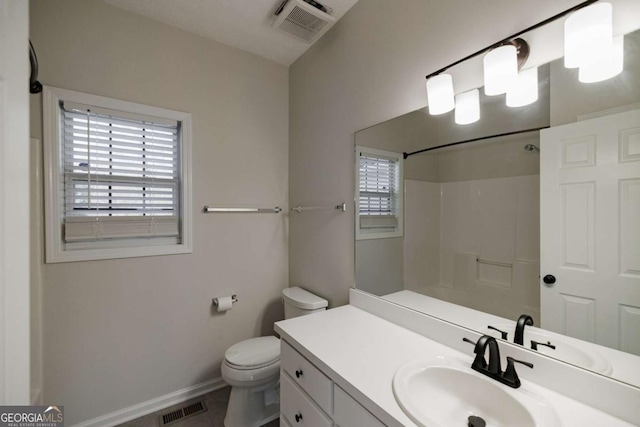 bathroom with vanity, a shower, and toilet