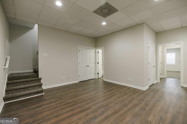 empty room featuring dark hardwood / wood-style flooring and a paneled ceiling