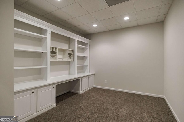 unfurnished office with built in desk and dark colored carpet