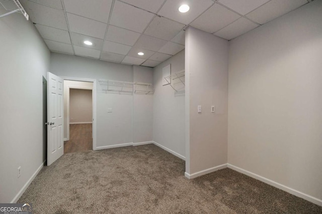 spacious closet with a drop ceiling and carpet flooring