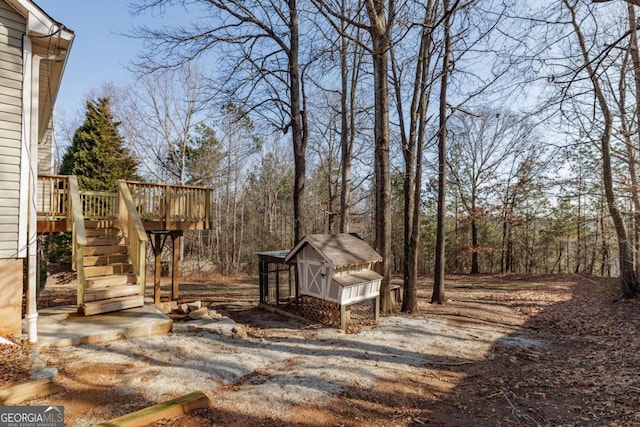 view of yard featuring an outdoor structure and a deck