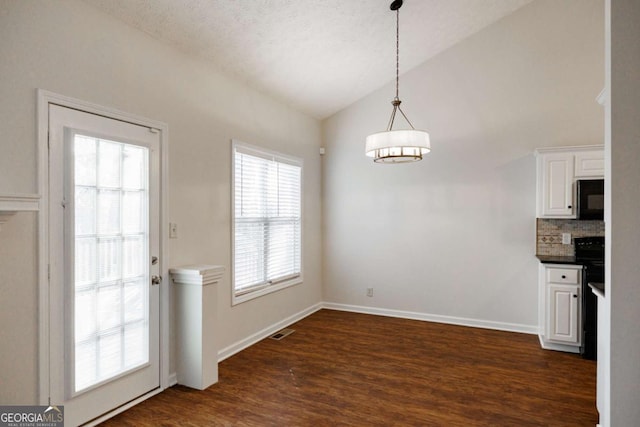 unfurnished dining area with lofted ceiling and dark hardwood / wood-style floors