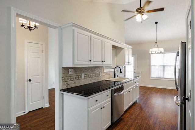 kitchen featuring vaulted ceiling, sink, white cabinets, decorative backsplash, and stainless steel appliances