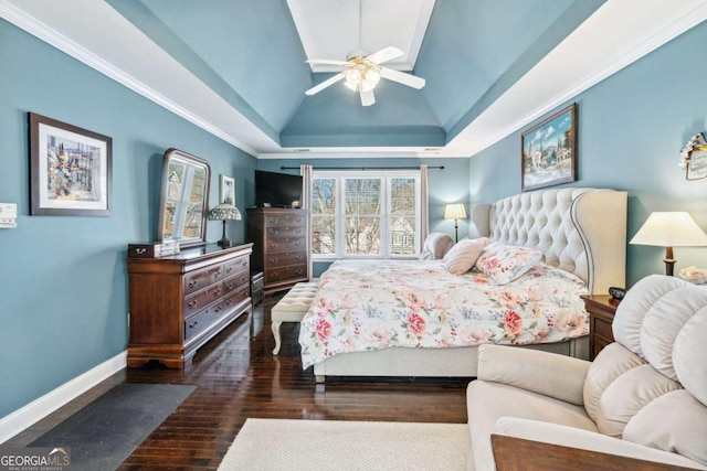 bedroom with vaulted ceiling, dark hardwood / wood-style floors, ceiling fan, and a tray ceiling