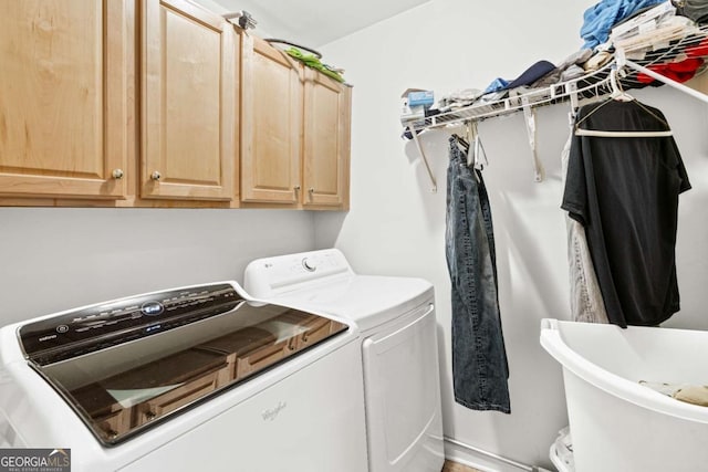 laundry room featuring cabinets and washer and clothes dryer