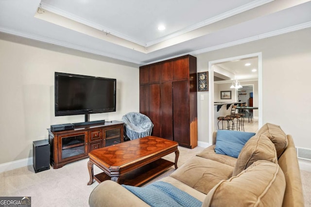 carpeted living room featuring crown molding, a raised ceiling, and a notable chandelier