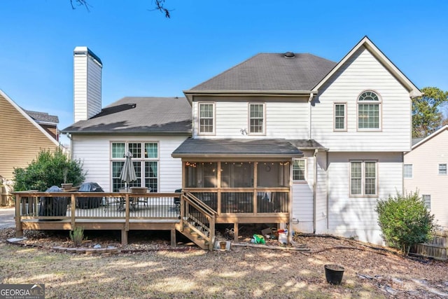 rear view of house featuring a wooden deck and a sunroom