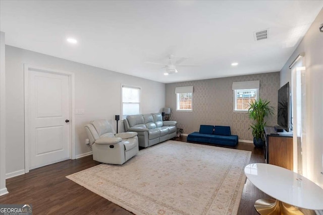 living room featuring ceiling fan and dark hardwood / wood-style floors