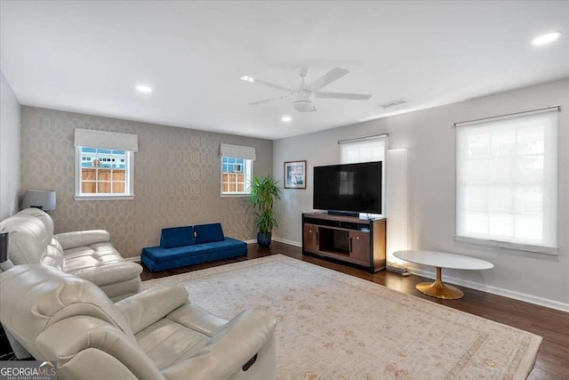 living room featuring dark wood-type flooring and ceiling fan