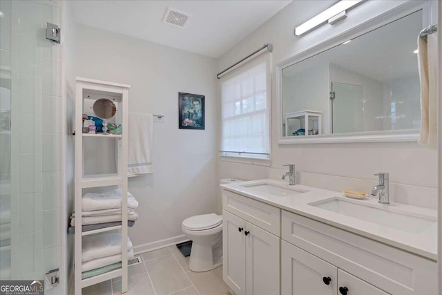 bathroom featuring vanity, walk in shower, tile patterned floors, and toilet