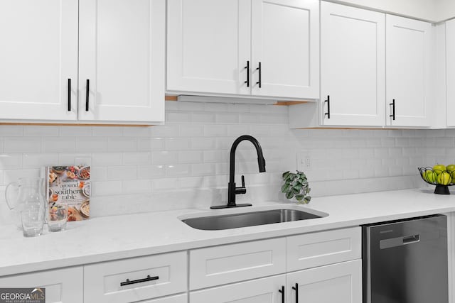 kitchen featuring sink, tasteful backsplash, light stone countertops, white cabinets, and stainless steel dishwasher