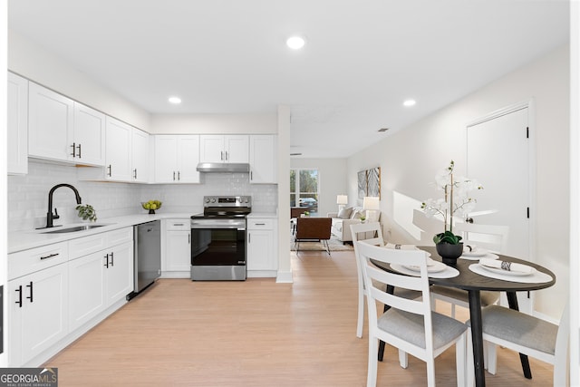 kitchen with appliances with stainless steel finishes, sink, light hardwood / wood-style flooring, and white cabinets