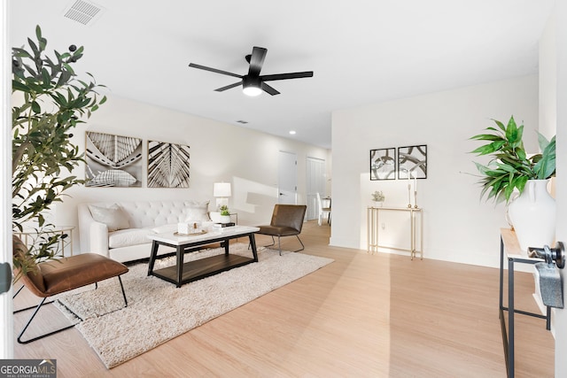 living room with ceiling fan and light hardwood / wood-style flooring