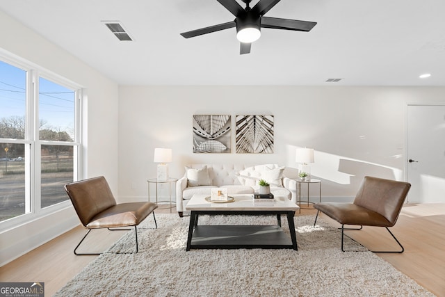 living room featuring ceiling fan and light hardwood / wood-style floors