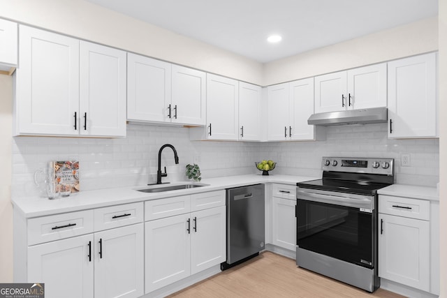 kitchen with appliances with stainless steel finishes, sink, and white cabinets