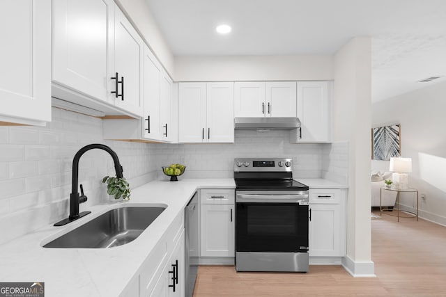 kitchen with white cabinetry, appliances with stainless steel finishes, sink, and light wood-type flooring