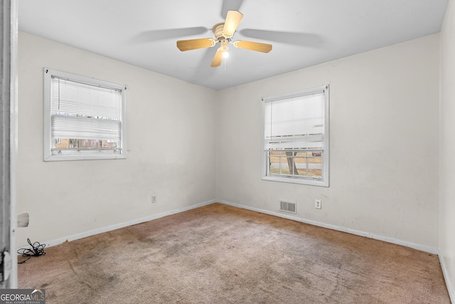 carpeted spare room featuring ceiling fan