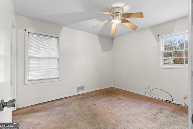 empty room featuring light colored carpet and ceiling fan