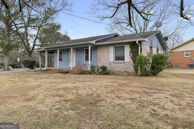 view of front of house featuring a front yard, central air condition unit, and covered porch