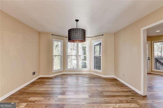 unfurnished dining area featuring light wood-type flooring