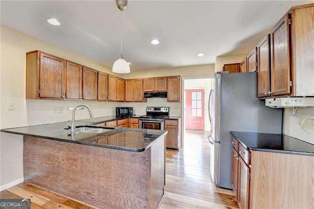 kitchen with sink, decorative light fixtures, stainless steel appliances, and kitchen peninsula