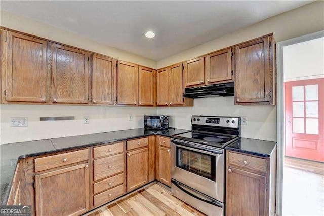 kitchen with stainless steel electric range and light hardwood / wood-style floors