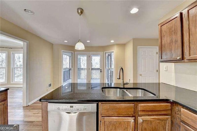 kitchen with pendant lighting, sink, stainless steel dishwasher, french doors, and light wood-type flooring