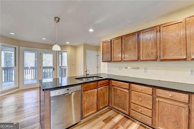 kitchen featuring pendant lighting, sink, dishwasher, kitchen peninsula, and light wood-type flooring