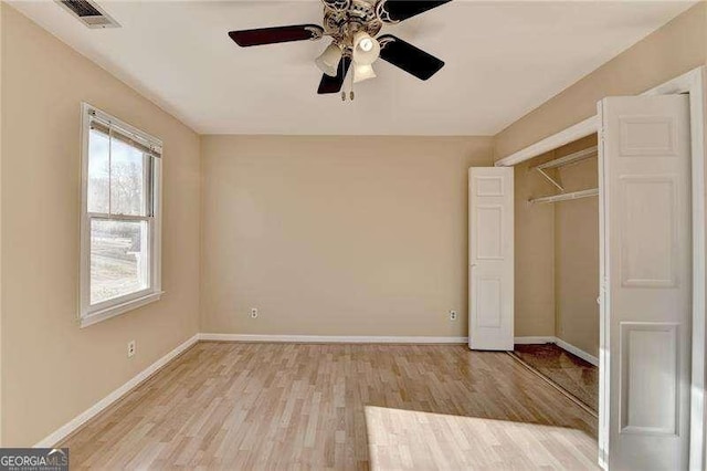 unfurnished bedroom featuring ceiling fan, light hardwood / wood-style floors, and a closet