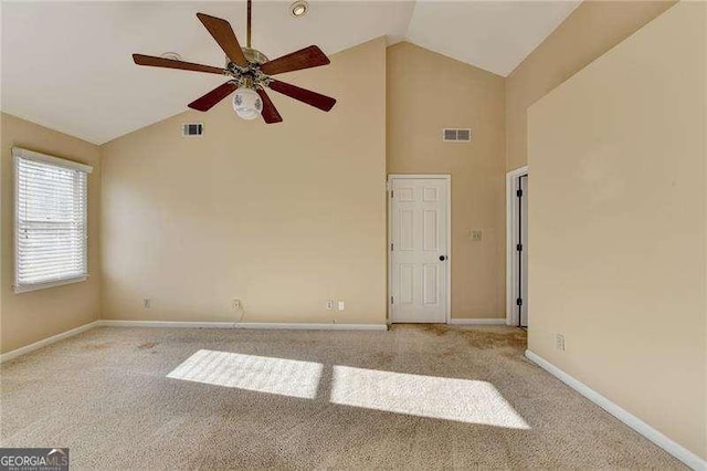 carpeted empty room with high vaulted ceiling and ceiling fan