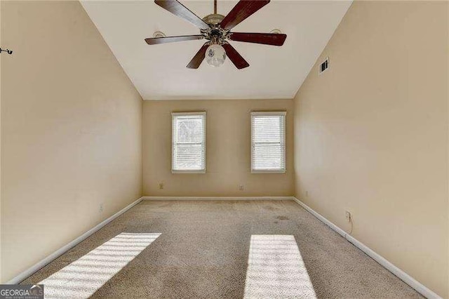 carpeted spare room featuring vaulted ceiling and ceiling fan