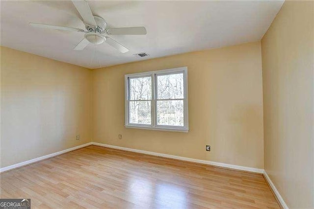 empty room with ceiling fan and light hardwood / wood-style floors