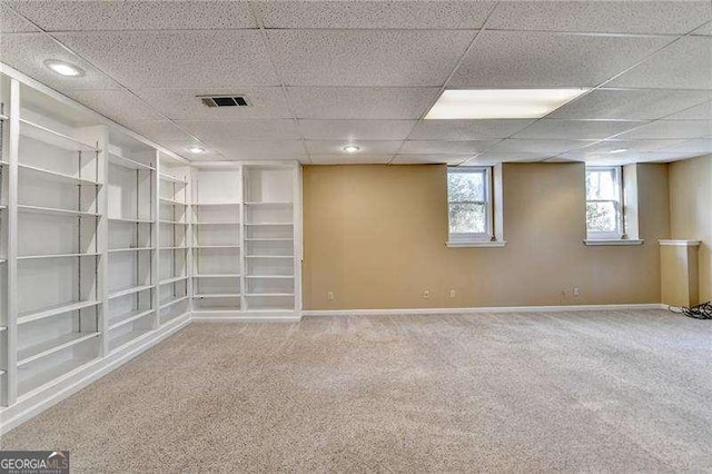 spare room with a paneled ceiling and carpet flooring