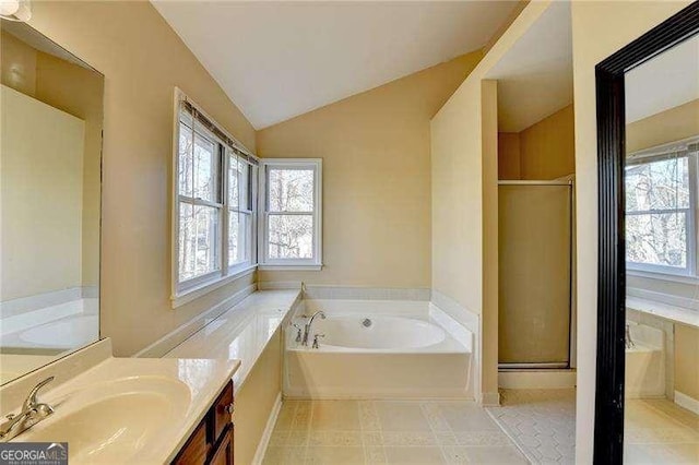 bathroom featuring lofted ceiling, a bathtub, and vanity