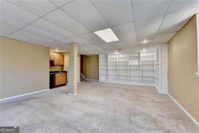 interior space with light carpet, a paneled ceiling, and built in features