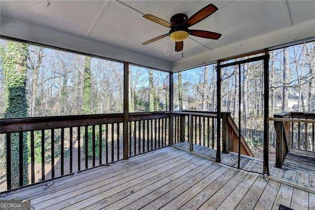 unfurnished sunroom featuring ceiling fan