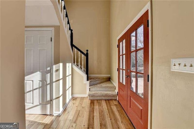 entryway with light hardwood / wood-style floors and french doors