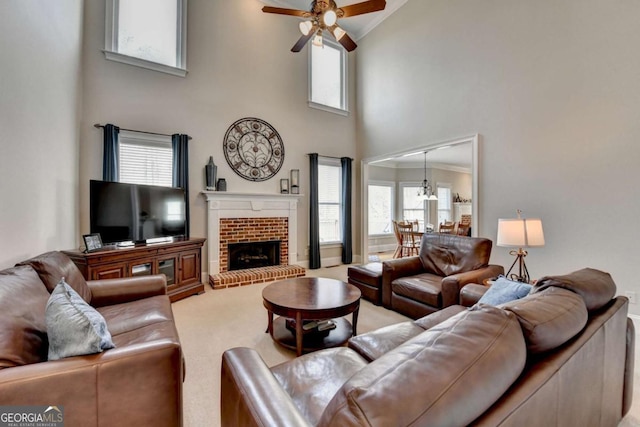 carpeted living room featuring a fireplace, ceiling fan, and a high ceiling