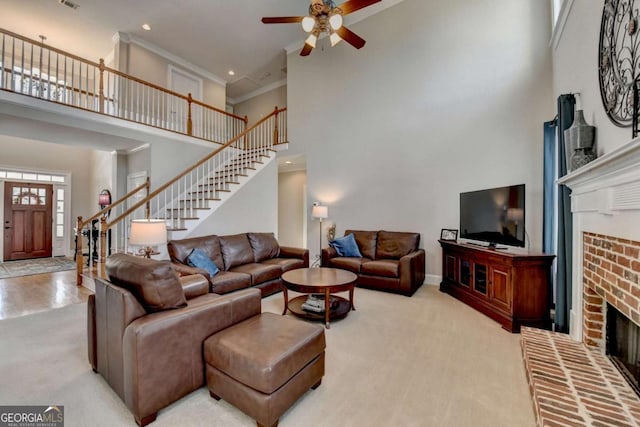 carpeted living room featuring crown molding, ceiling fan, a brick fireplace, and a high ceiling