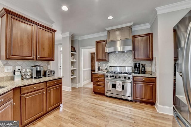 kitchen with ventilation hood, ornamental molding, stainless steel appliances, light stone countertops, and light hardwood / wood-style floors