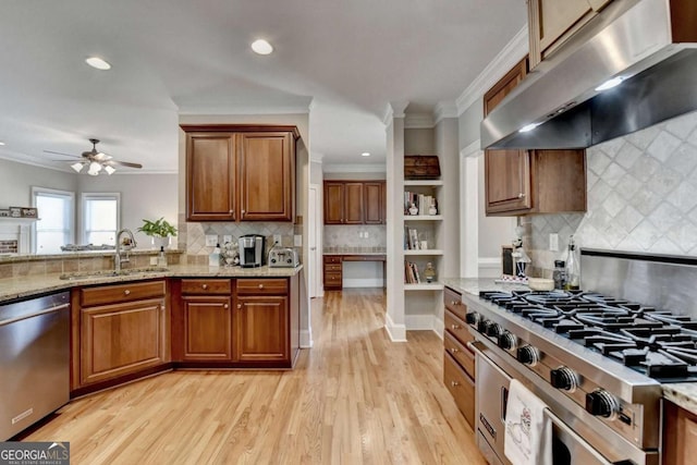 kitchen with crown molding, appliances with stainless steel finishes, sink, and light stone counters