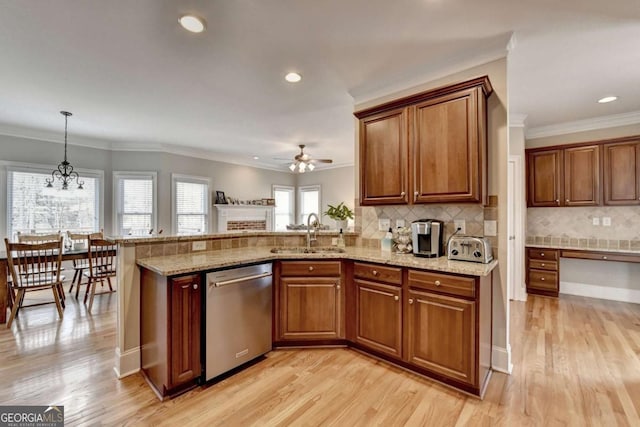 kitchen with decorative light fixtures, dishwasher, sink, and kitchen peninsula