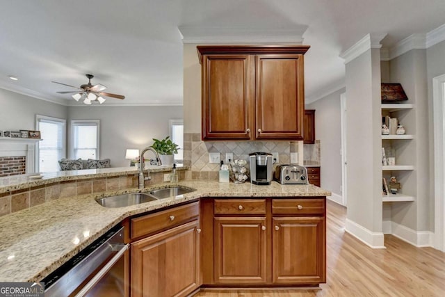 kitchen with sink, ornamental molding, light stone countertops, and dishwasher